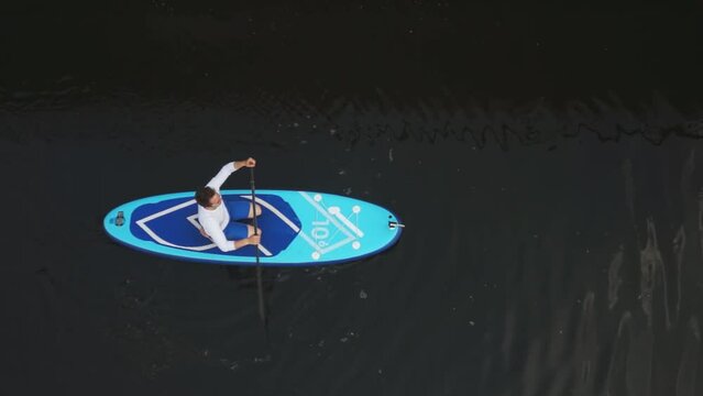swim across the river. a man floats on a board. view from above. High quality Full HD video recording