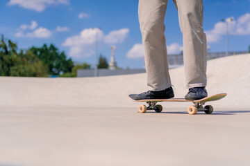 Young guy skateboarder skateboarding around the city skatepark next to the figures for a stunts...