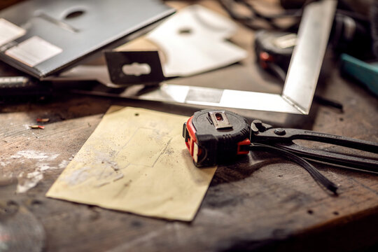 A measuring tape and a sketch on a work bench in a hobby garage workshop