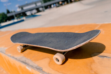 A close-up of a skateboard that stands on a bench in a city skatepark the concept of adrenaline...