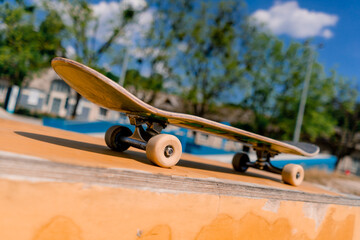 A close-up of a skateboard that stands on a bench in a city skatepark the concept of adrenaline...