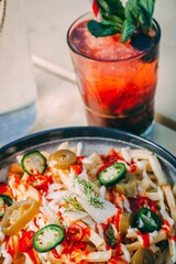 Refreshing drink and a bowl of french fries topped with sauce