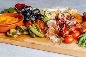 Mix of different snacks and appetizers on a wooden board