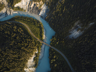 Aerial drone view of a canyon filled by a glacier river crossed by a railroad, Rheinschlucht, Flims, Graubunden, Switzerland.