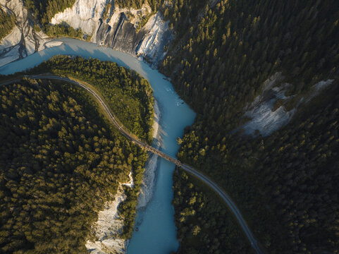Aerial drone view of a canyon filled by a glacier river crossed by a railroad, Rheinschlucht, Flims, Graubunden, Switzerland.