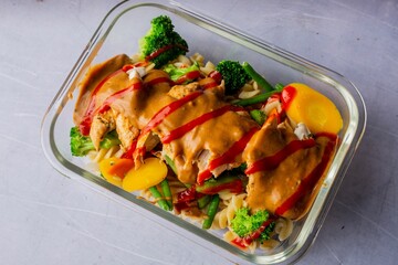 Closeup of a  plate with a variety of fresh ingredients, including chicken, broccoli, and other