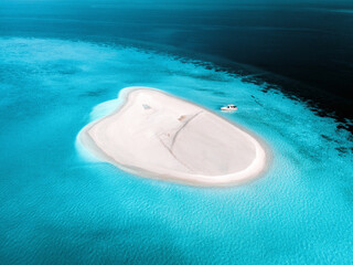 Aerial view of a person with a speedboat along South Ari Atoll, Maldives.