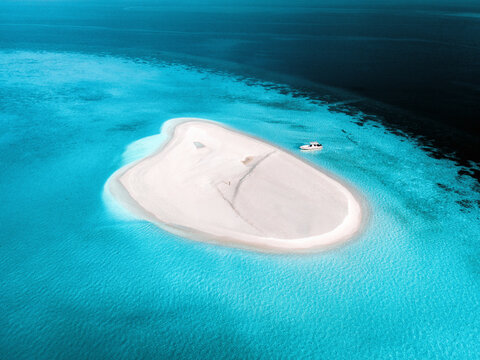 Aerial view of a person with a speedboat along South Ari Atoll, Maldives.