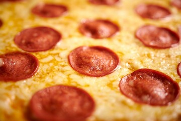 Freshly-made pizza with a topping of pepperoni, cheese and other spices