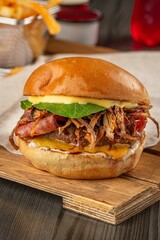 Vertical shot of a delicious hamburger with onion and ham on the table