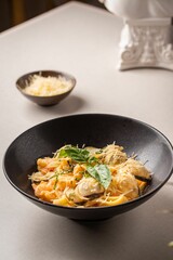 Bowl of freshly-made delicious pasta with seafood on the table