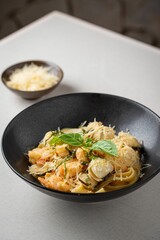 Bowl of freshly-made delicious pasta with seafood on the table