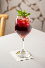 Vertical shot of a glass of delicious sangria with mint garnish on the table