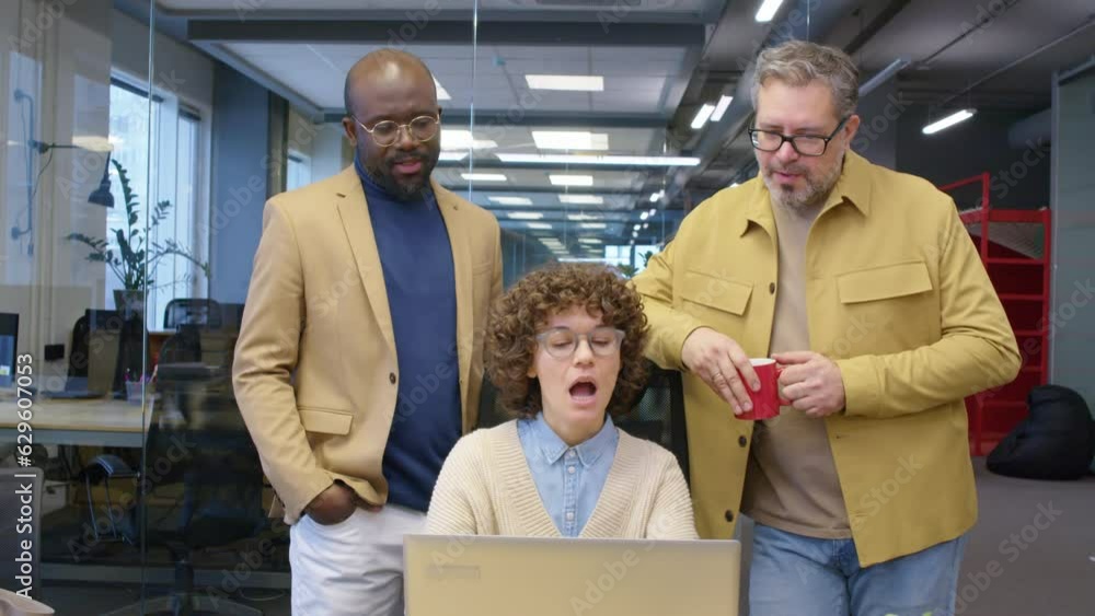 Poster front view of diverse team of managers having project discussing looking at laptop screen in office 