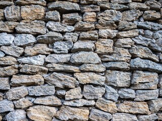 Outdoor stone wall composed of assorted sizes of rocks