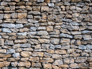 Outdoor stone wall composed of assorted sizes of rocks