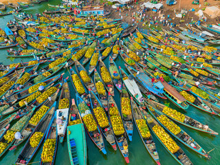 Bangladesh - 15 February 2023: Aerial view of floating market of seasonal fruits on the boats in Kaptai Lake, Rangamati, Bangladesh.