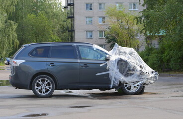 A new black wrecked car after an accident is covered with plastic wrap, Iskrovsky Prospekt, Saint Petersburg, Russia, July 24, 2023