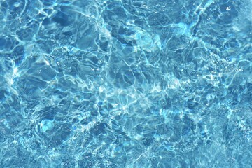 Blue water with ripples on the surface. Defocus blurred transparent blue colored clear calm water...