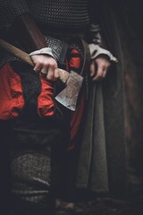 Man dressed in authentic medieval armor standing in the middle of forest