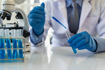 Scientists working under a microscope analyzed a sample of blue velu in vitro. Young biotechnology specialists using advanced equipment in the Medical Science Laboratory: