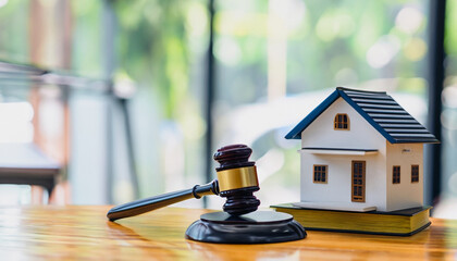 house and judges gavel on table in a courtroom or law enforcement office - obrazy, fototapety, plakaty