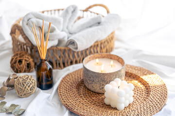 Spa composition with aroma diffuser and candles on a blurred background.