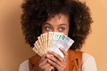 joyful brazilian woman with money, brazilian real in studio shot. finance, investment, offer, loan concept. 