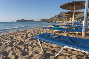 Beach lounge chairs on the shore of Falasarna beach in Crete Island, Greece