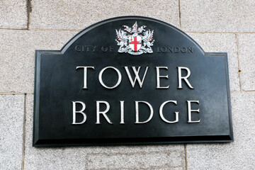 Obraz premium Tower Bridge Sign Plaque with the City of London logo and coat of arms, on the wall of the iconic bridge, signage of famous London attraction