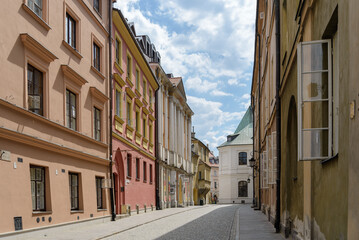 Outdoor sunny view on sidewalk along city wall and Old Town in Warsaw, Poland.
