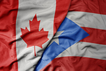 big waving realistic national colorful flag of canada and national flag of puerto rico .