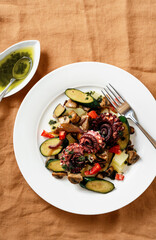 Salad of boiled octopus, potatoes, fried vegetables and green sauce. restaurant