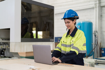 Female engineer worker working with computer in industry factory. Female technician using laptop computer control and maintaining machine in the factory