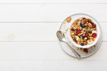 Cooking a wholesome breakfast. Granola with Various dried fruits and nuts in a bowl. The concept of a healthy dessert. Flat lay, top view with copy space
