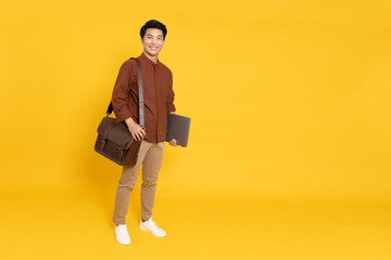 Portrait of young Asian businessman smile and holding laptop and brown leather bag isolated on...