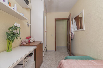 A bedroom with a single bed with a pink bedspread