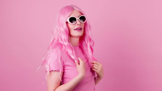 Fashionable woman in total pink with smiling face, trend outfit for confidence, positivity, beauty, advert. Relaxed lady posing looking at camera, pride emotion, makeup in studio on pink background