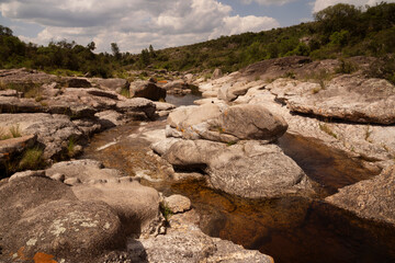 Panorama view of the river flowing along the rocky hills and forest in a summer sunny day.	
