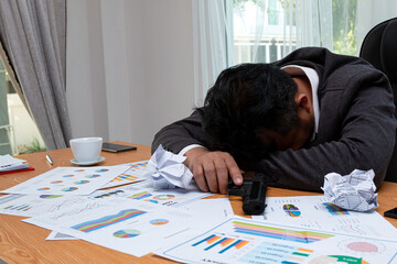 Cruel Intentions: Asian Businessman sleeping holding a Gun in High-Stress Environment on desk