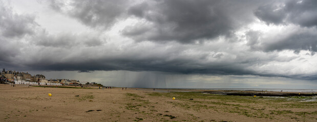 Saint-Aubin-Sur-Mer, France - 07 16 2023:  View of a cloudy rainy sky above the sea from the beach. © Franck Legros