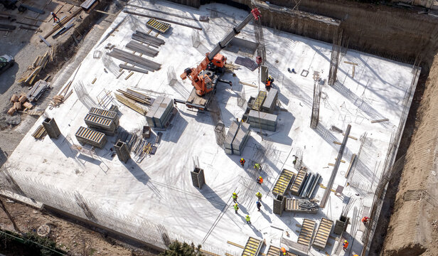 Aerial Top Down View on a Constructions Site with Team of Engineers and Worker