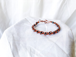 Handmade bracelet with metallic beads. Wire copper wrapped accessories, white background.