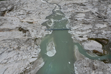 aerial view of the metal bridge that crosses the river produced by the Adamello glacier in Trentino