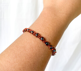 brown skin asian hand with wire bracelet