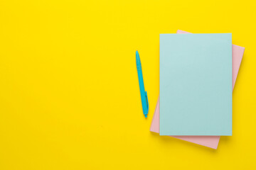 Notebooks with stationery on color background, top view