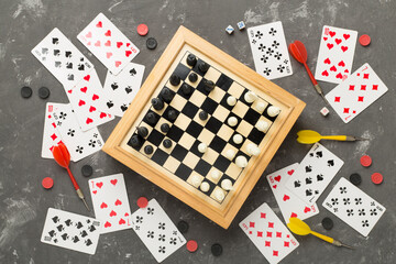 Different board games on concrete background, top view