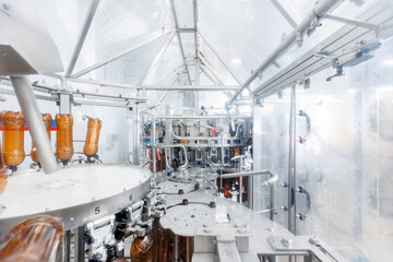 Process pasteurization Brown plastic bottles with beer, moving on conveyor. Concept production line of brewery, modern food industry