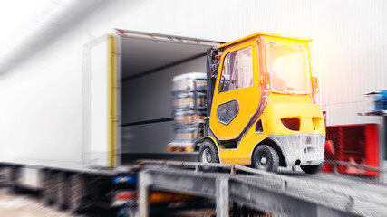 Forklift is putting cargo from warehouse to truck outdoors, sunlight motion blur effect