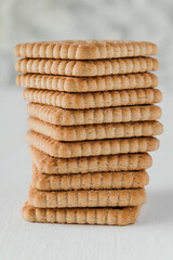 Stacked sweet biscuits on a white background. Side view. Close up.